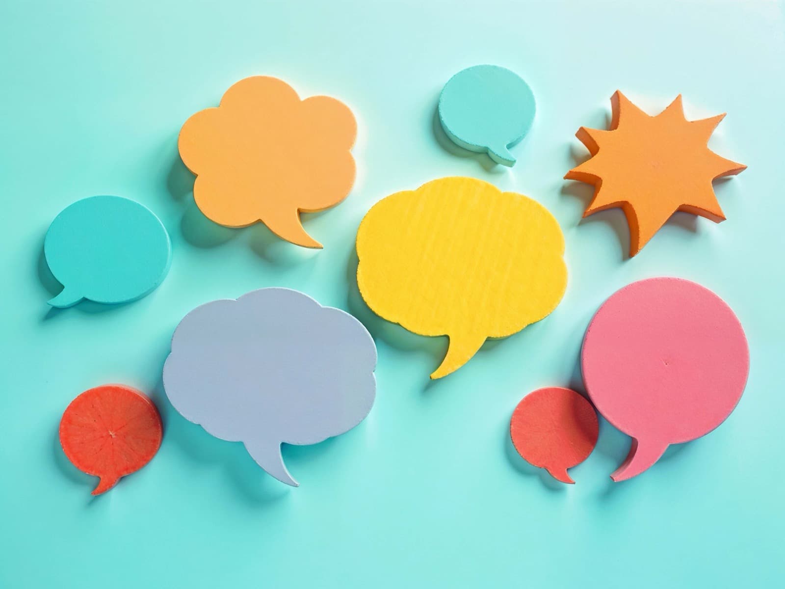 Bulles de conversation colorées sur fond uni, symbole de plusieurs langues