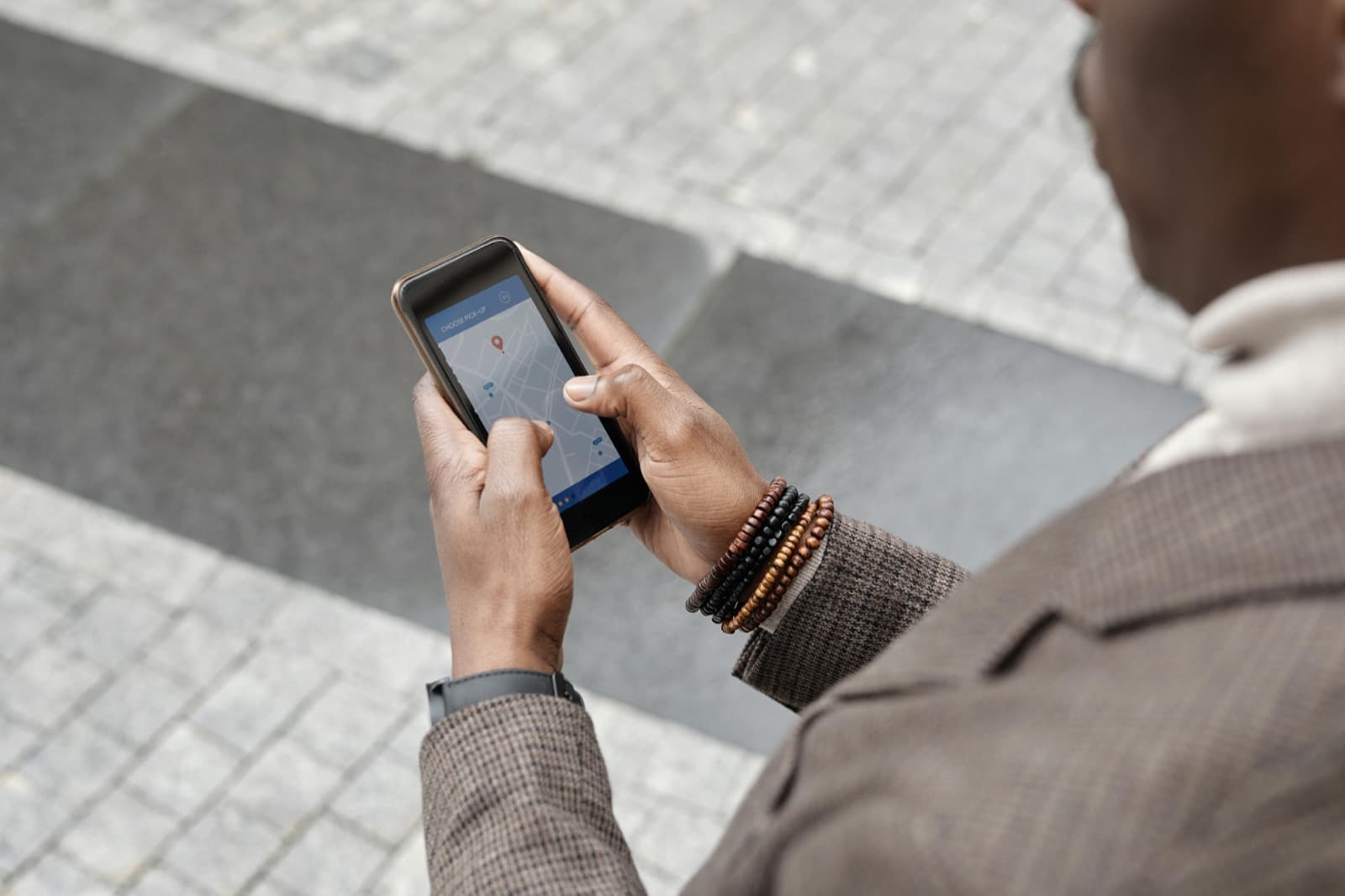 Personne consultant une carte avec un repère de lieu sur son téléphone dans la rue